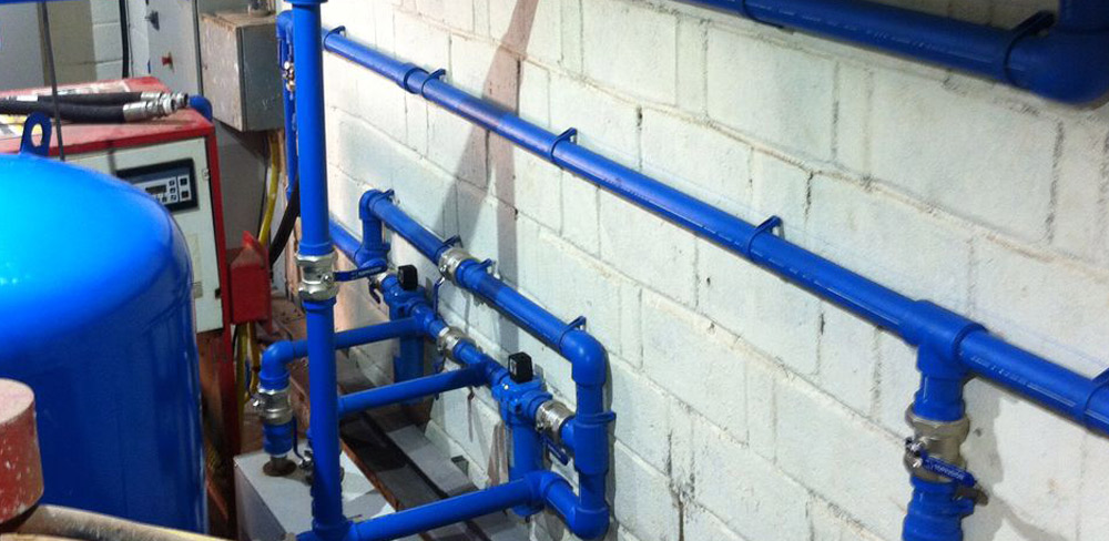 Rede de tubulações azuis instalada em ambiente industrial